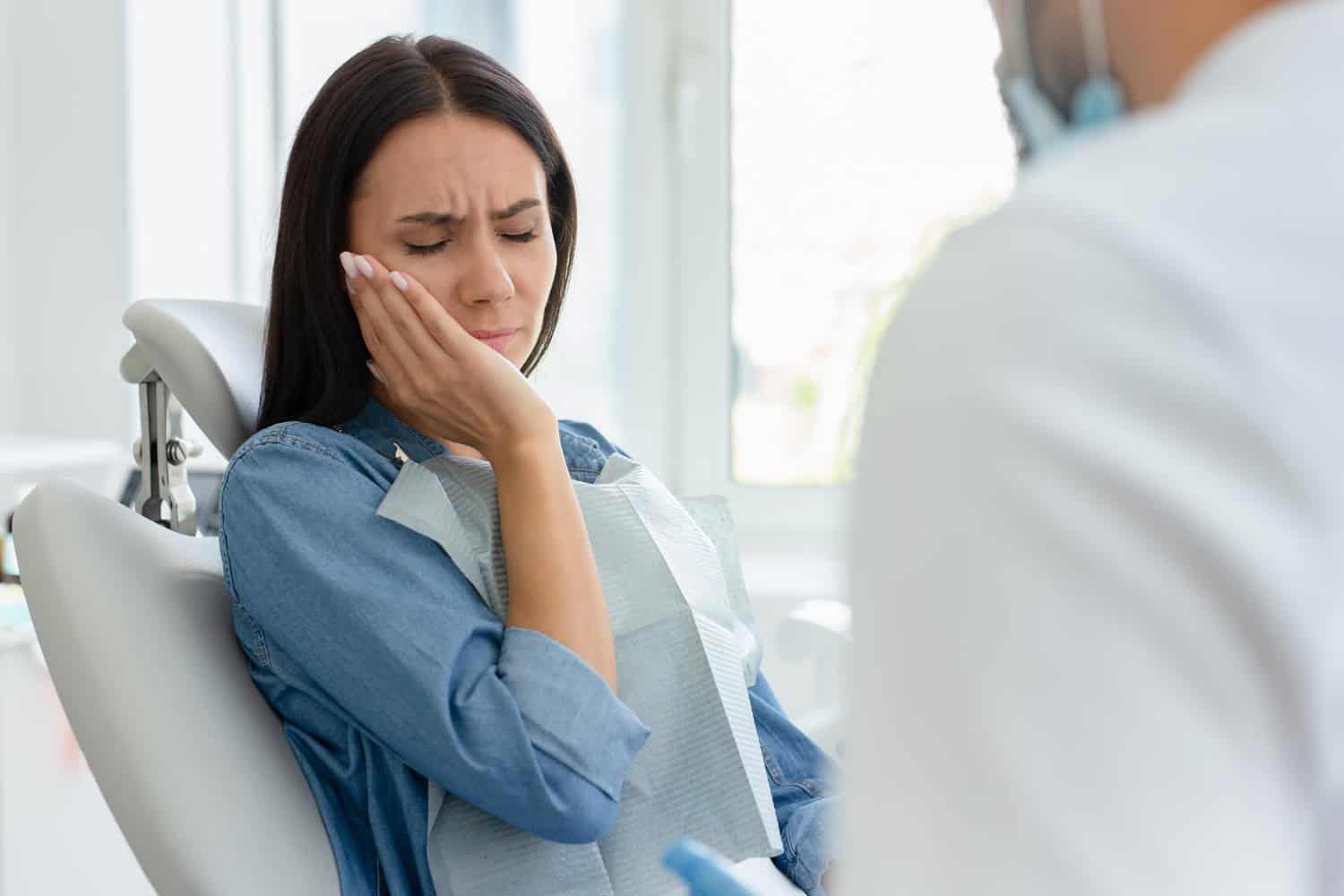 Patient experiencing tooth pain during a dental appointment, showing discomfort and warning signs that need attention.