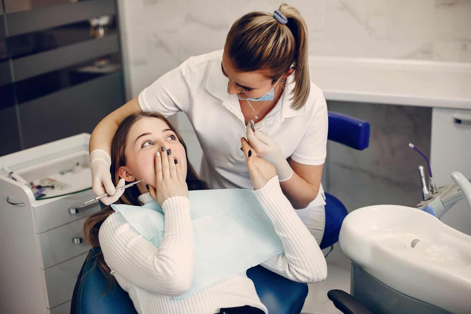 Dental professional examining a patient’s teeth during a routine dental examination and treatment consultation.