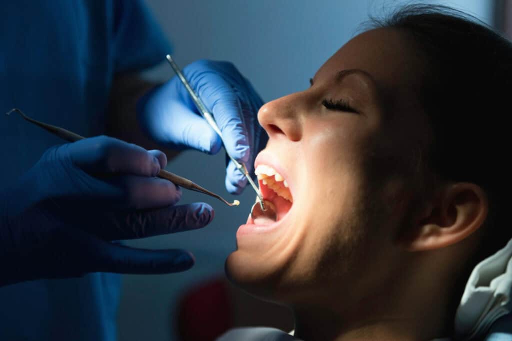 Periodontist examining a patient’s teeth and gums during a dental examination.