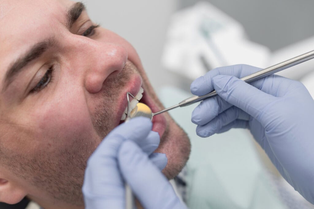 Periodontist examining a patient for gum recession and gum grafting treatment in Timonium, MD.