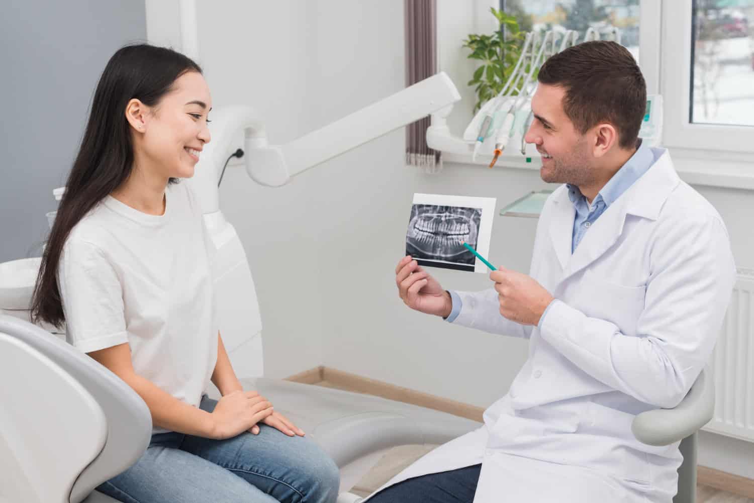 Dentist explaining a dental X-ray to a patient during a consultation about oral health and treatment.