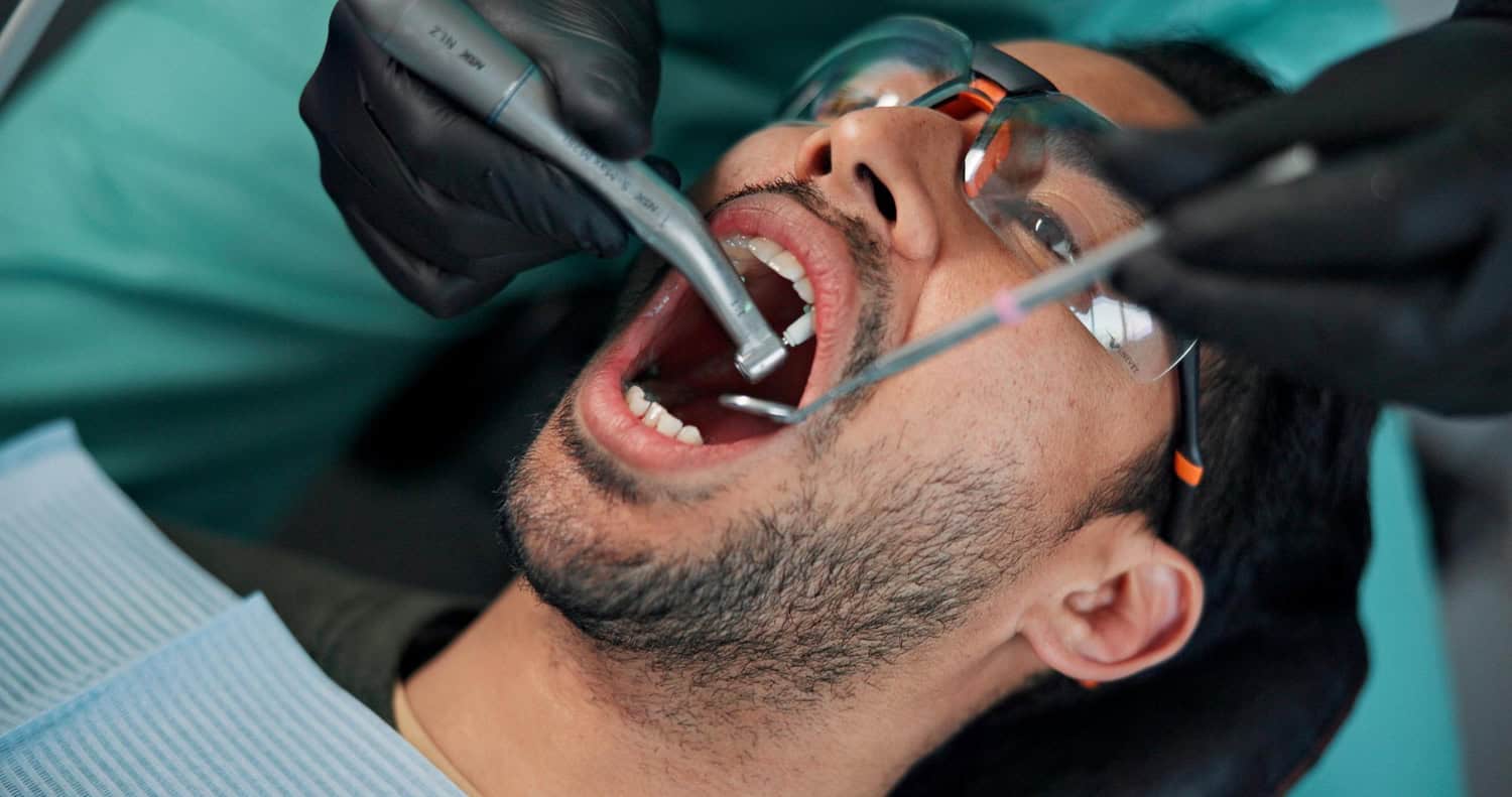 Dental professional performing a tooth extraction procedure on a patient during an oral surgery appointment.