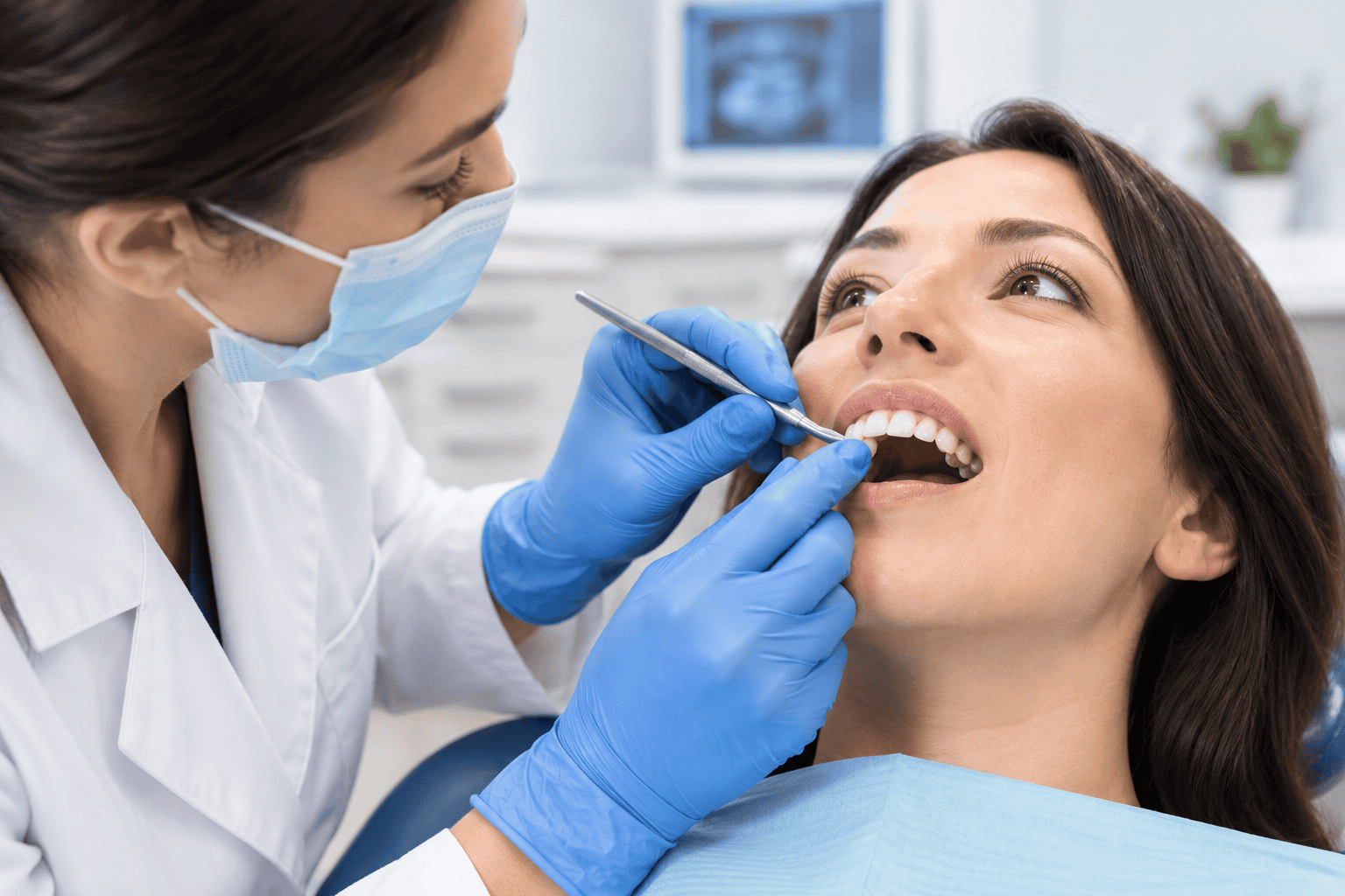 Dentist examining a loose tooth during a dental checkup for gum disease and periodontal symptoms.