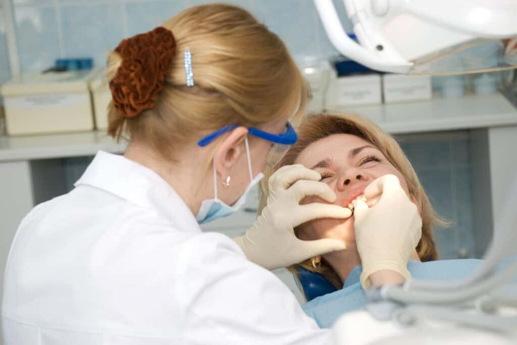 Dentist examining a patient's mouth during a dental procedure, highlighting oral care, treatment, and implant dentistry and care.