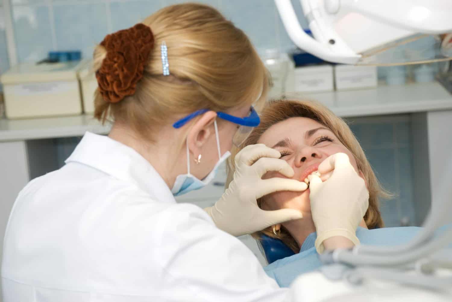 Dentist examining a patient's mouth during a dental procedure, highlighting oral care, treatment, and implant dentistry and care.